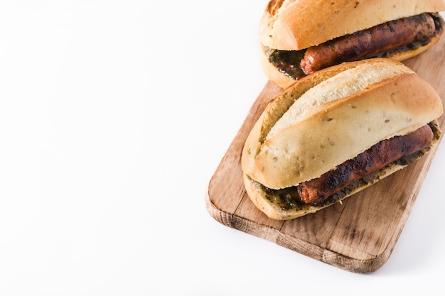 Choripan. Traditional Argentina sandwich with chorizo and chimichurri sauce. isolated on white 