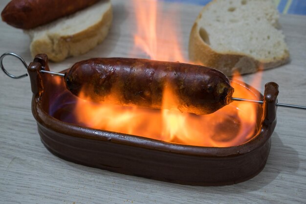 Chorizo al infierno typical dish of spanish cuisine chorizo in a clay bowl with alcohol