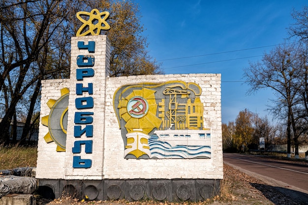 Foto segno informativo di chernobyl sulla strada contro il cielo blu