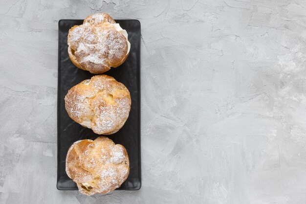 Choux Bun met slagroom en suikerpoeder erop Choux gebakdessert Franse slagroom