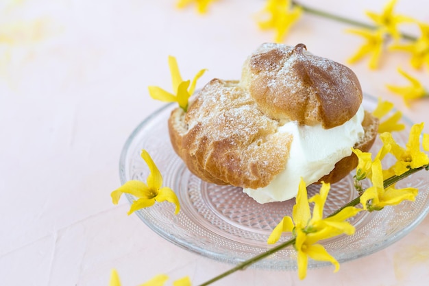 Choux Bun with whipped cream and sugar powder on top Choux pastry dessert French cream puff