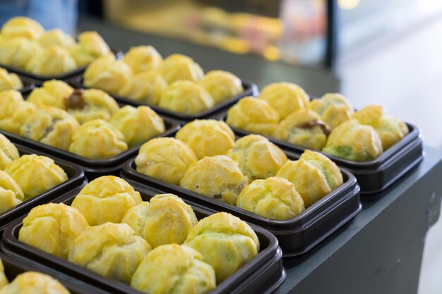 Choux cream in bakery tray on table.