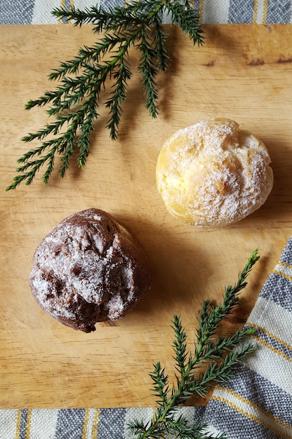 Photo choux cream puffs on wooden plate