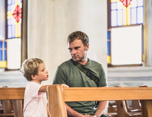 Christelijke vader vertelt zijn zoon Bijbelverhalen over Jezus die in de kerk zit Geloof religieus onderwijs moderne kerk vaderdag vaderlijke verantwoordelijkheden vader invloed op vorming zoon wereldbeeld