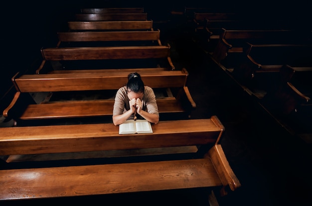 Christelijke vrouw bidden in de kerk.