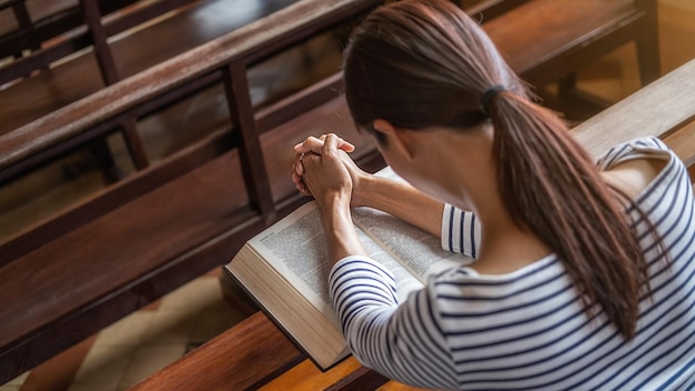 Foto christelijke vrouw die bidt op de heilige bijbel in de openbare kerk