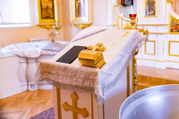 Christening bath and the altar at the orthodox church during christeningbaptismal font Accessories for the christening of children icons of candles