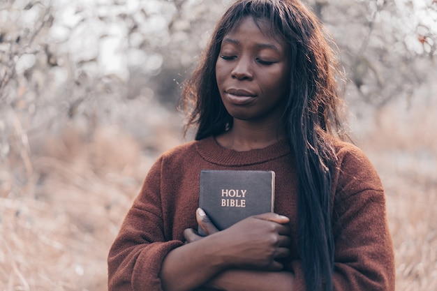 christian afro girl holds bible in her hands