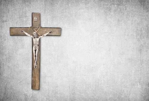 Christian background with crucifix of Jesus Christ on gray concrete wall