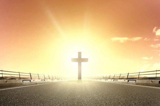 Christian cross at the end of the asphalt road