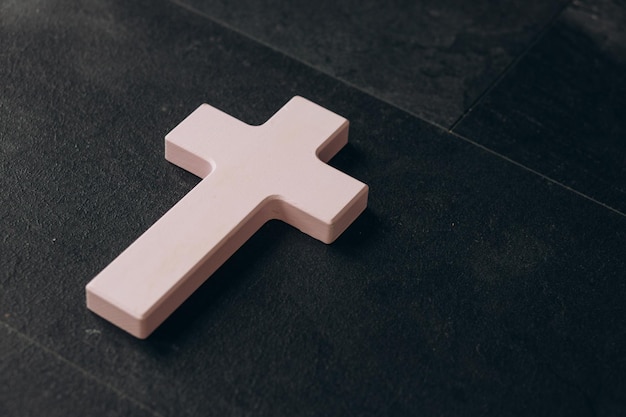 Christian cross on a textured black background Religion concept Pink cross