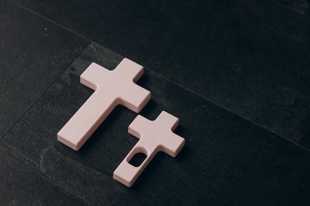 Christian cross on a textured black background religion concept\
pink cross