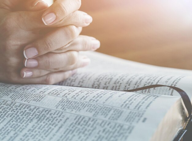 Christian hands praying with the open book