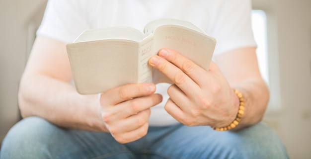 The Christian holds the Bible in his hands. Reading the bible. The concept of faith, spirituality and religion