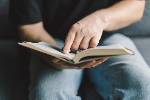 Christian man holds holy bible in hands Reading the Holy Bible in a home Concept for faith spirituality and religion Peace hope