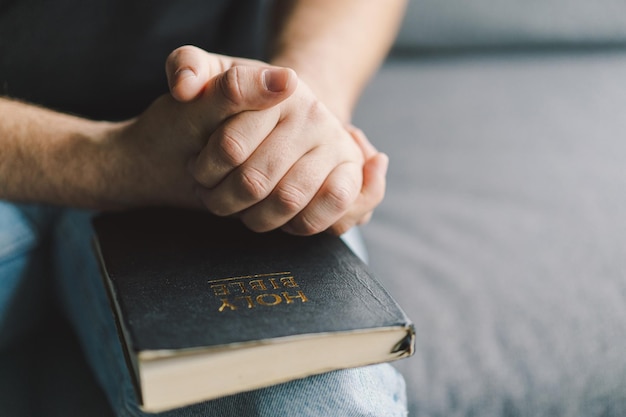 Christian man holds holy bible in hands Reading the Holy Bible in a home Concept for faith spirituality and religion Peace hope