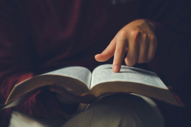 Foto le mani dell'uomo cristiano mentre legge le letture bibliche istruzione biblica spiritualità e religione