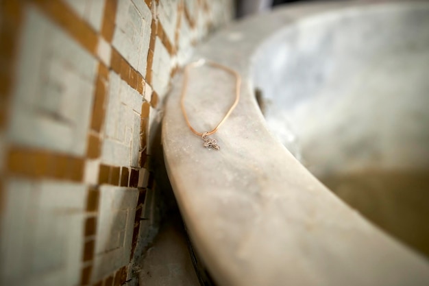 Photo christian pectoral cross lies on the bowl for baptism in the temple