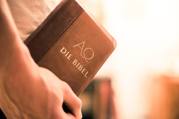 Фото Христианский проповедник молодой человек держит библию, молясь