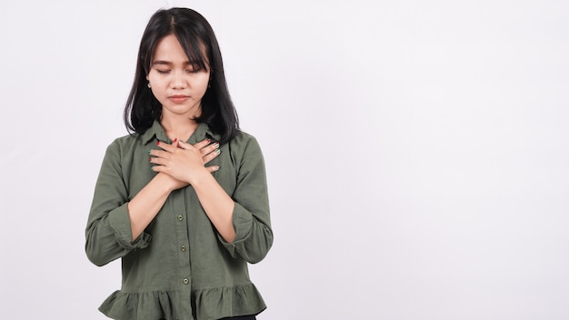 A Christian woman praying humbly isolated white wall