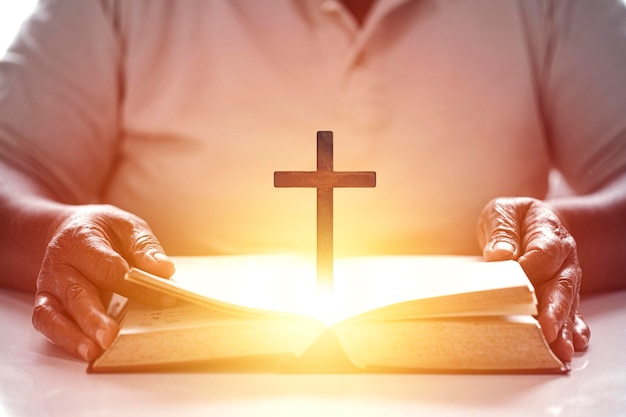 Christian wooden cross on open bible Holy concept