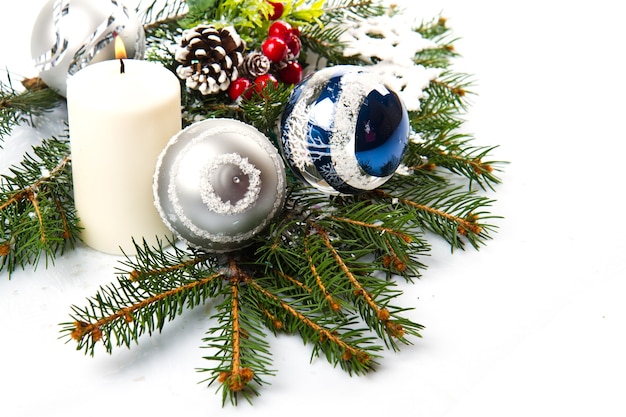 Christmas accessories in blue & fir tree branch on white