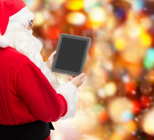 크리스마스, 광고, 기술, 그리고 사람들의 개념 - 빨간 불빛 배경 위에 태블릿 PC 컴퓨터가 있는 산타클로스 의상을 입은 남자