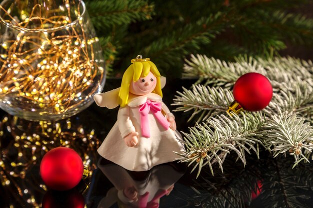 Christmas angel and fir branches on a dark background.