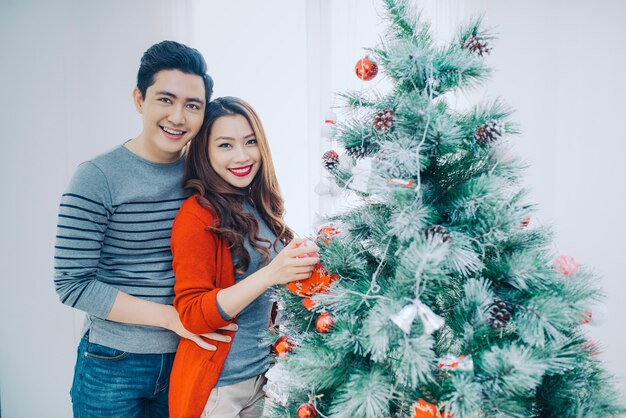 Christmas Asian Couple.Happy Smiling Family at home celebrating. New Year People