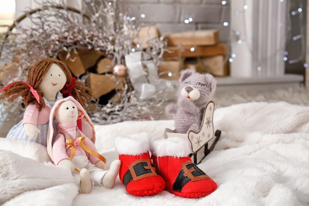 Christmas baby booties with toys on fluffy fabric indoors