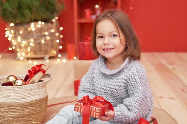 Christmas baby girl with gifts near of Christmas tree 