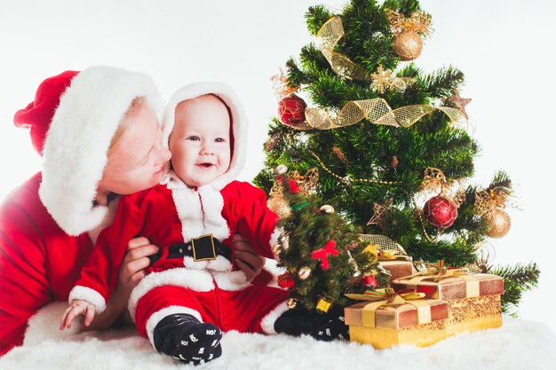 孤立したモミの木の下のクリスマスの赤ちゃんとお母さん