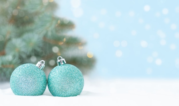 Christmas backdrop with Christmas ornaments in the snow in front of the Christmas tree