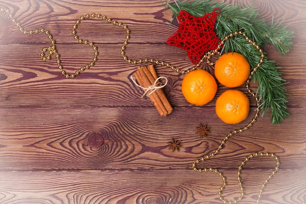 Christmas background - antique wood, fir branches, pine cone, candles and tangerines, New Year's decor. Flat lay, empty space.