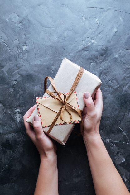 Photo christmas background. boxes with gifts in hands on dark