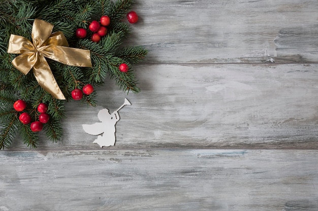 Christmas background. Christmas decor with branches of fir tree and an angel figurine