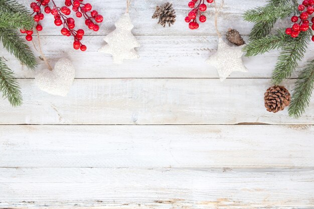 クリスマスの背景 - クリスマス飾りの要素と飾り雪片と白い木のテーブルに素朴。クリエイティブなフラットなレイアウトと、境界線とコピースペースのデザインによるトップビューの構図。