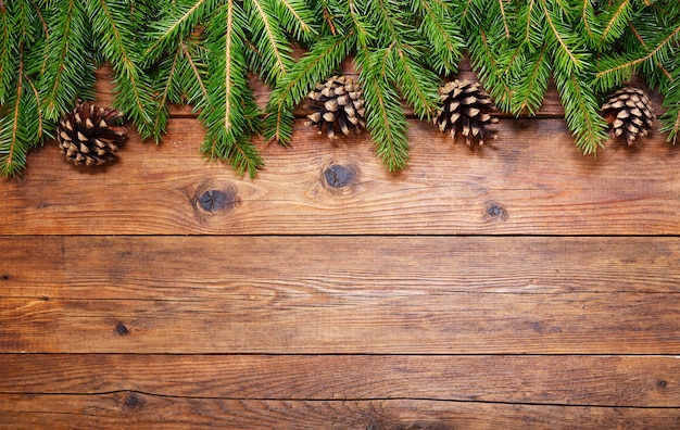 Sfondo di natale. decorazione natalizia con rami di abete su fondo in legno, vista dall'alto