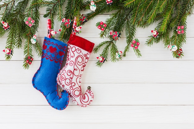 Фото Рождественский фон рождественская ель, рождественские носки на фоне белой деревянной доске с копией пространства.