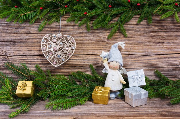 Christmas background. Christmas fir tree, Christmas tree toy, gifts on old wooden board background with copy space.