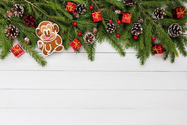 Christmas background. Christmas fir tree, gifts, monkey on white wooden background. Copy space