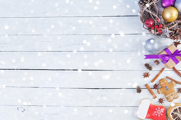 Christmas background. Christmas gift, toys, gingerbread cookies, spices and decorations on wooden table. Top view