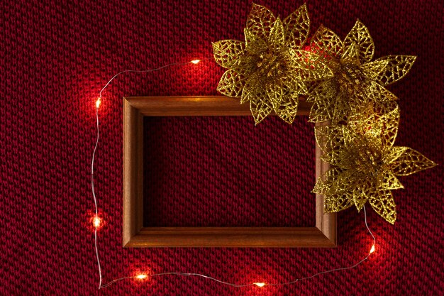 Christmas background christmas toys frame and garland lying on the knitted texture of a sweater