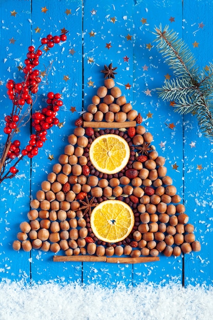 Christmas background. christmas tree shaped nuts, berries and spices