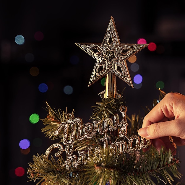 Christmas background concept beautiful decor bauble hanging on
the christmas tree with sparkling light spot blurry dark black
background copy space close up