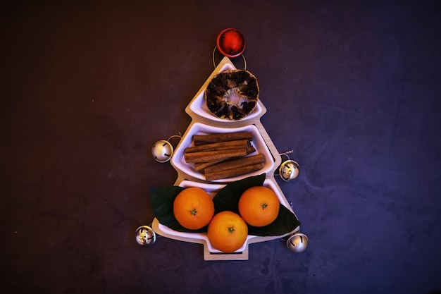 Christmas background Dish in the shape of a Christmas tree with balls decorations on the table