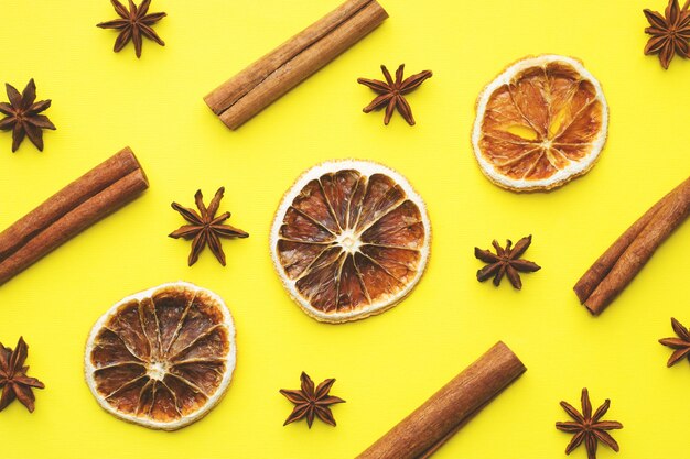 Christmas background of dried oranges, star anise and cinnamon. Yellow background. Flat lay