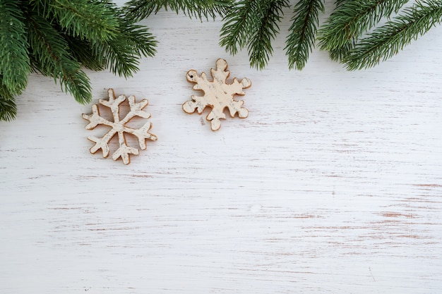 Рождественские листья ели фона и простоватые элементы, украшающие на белом деревянном столе. Creative Flat макет и вид сверху композиция с границей и копией пространства дизайна.
