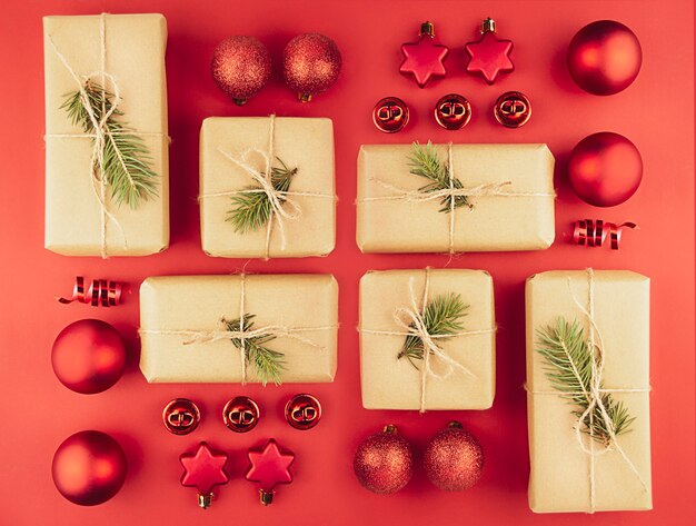 赤いクリスマスボールからのクリスマスの背景、赤い背景のギフトボックス、クローズアップ。フラットレイ。