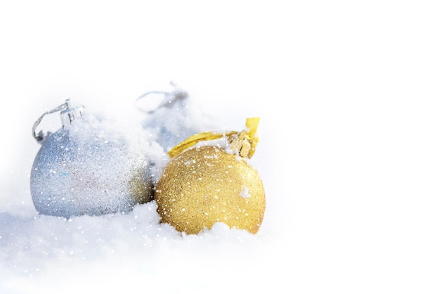Новогодний фон Золотые и серебряные елочные шары в снегу